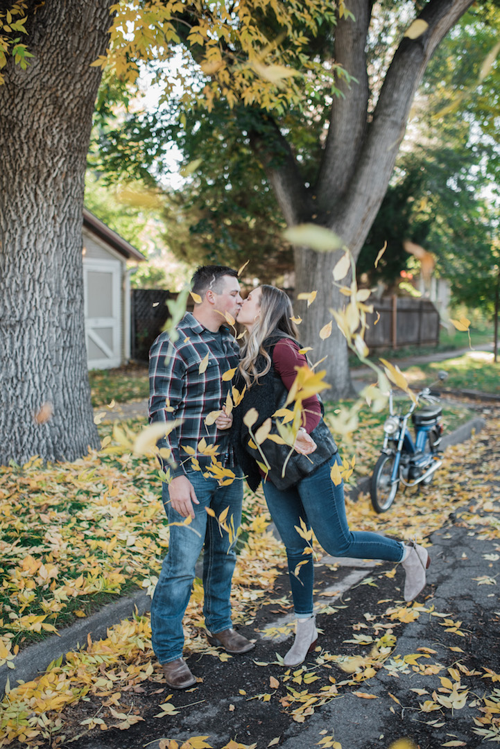 Max and Jenae kissing with yellow leaves falling