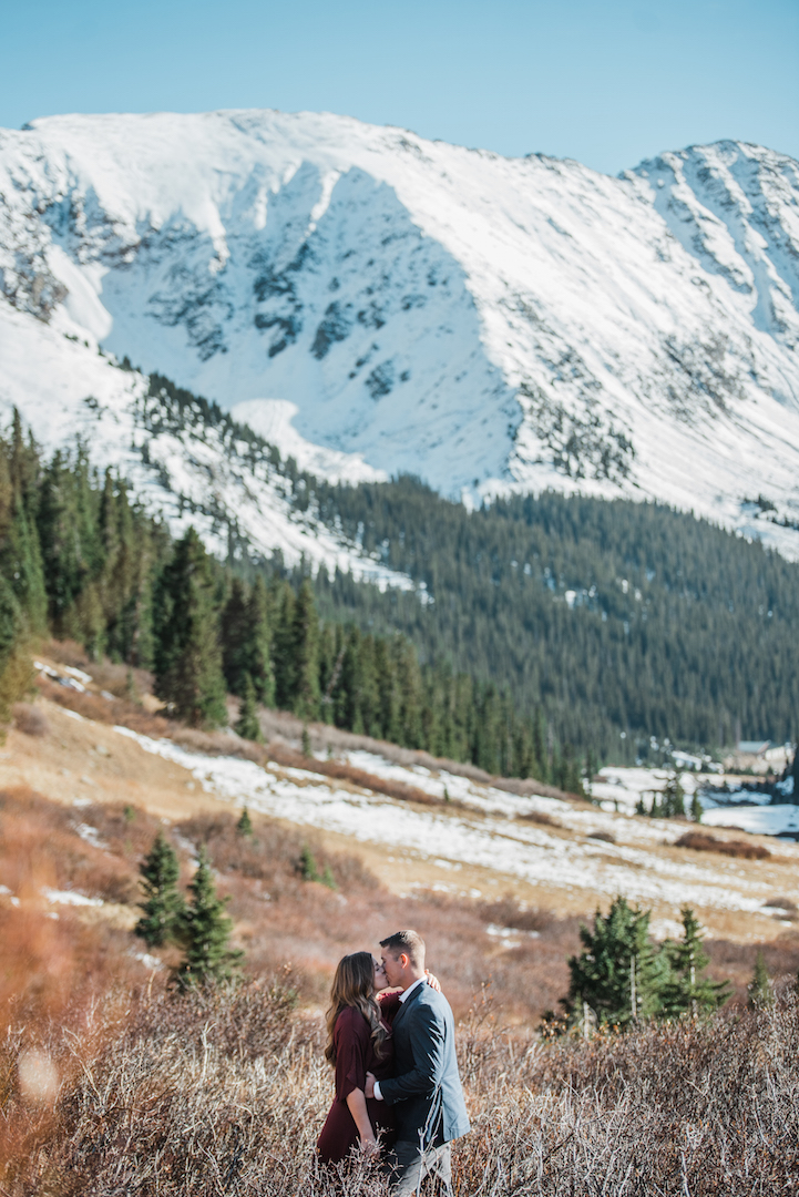 Taylor and Chris kissing with mountains in the background