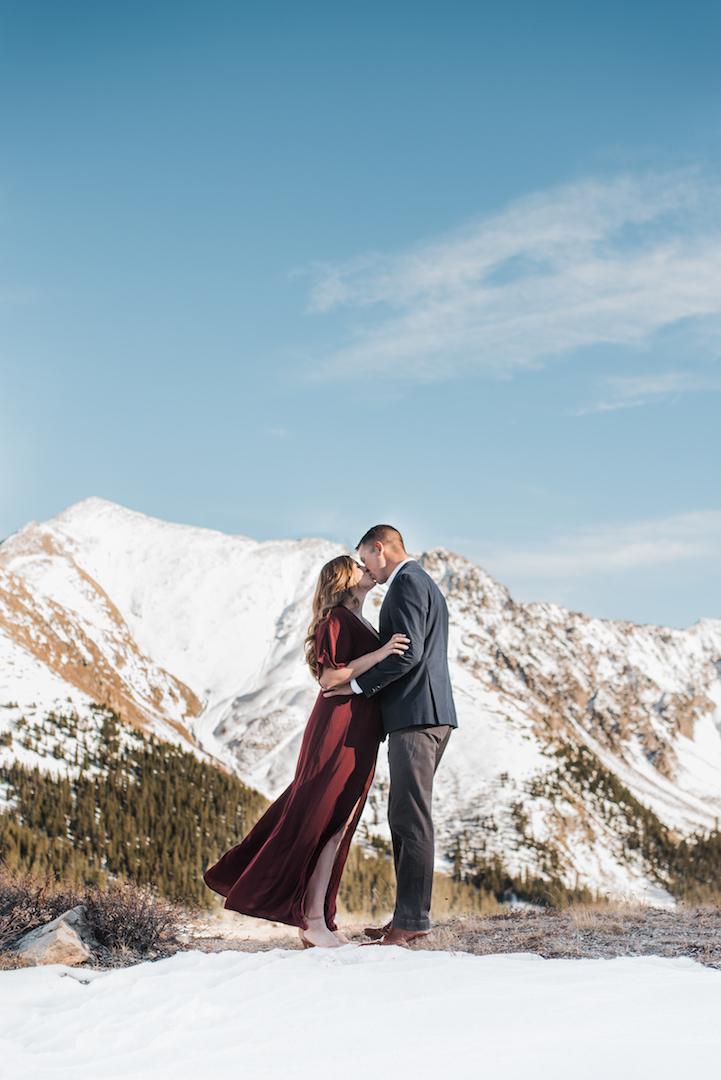 Taylor and Chris kissing on Loveland Pass with mountains in background