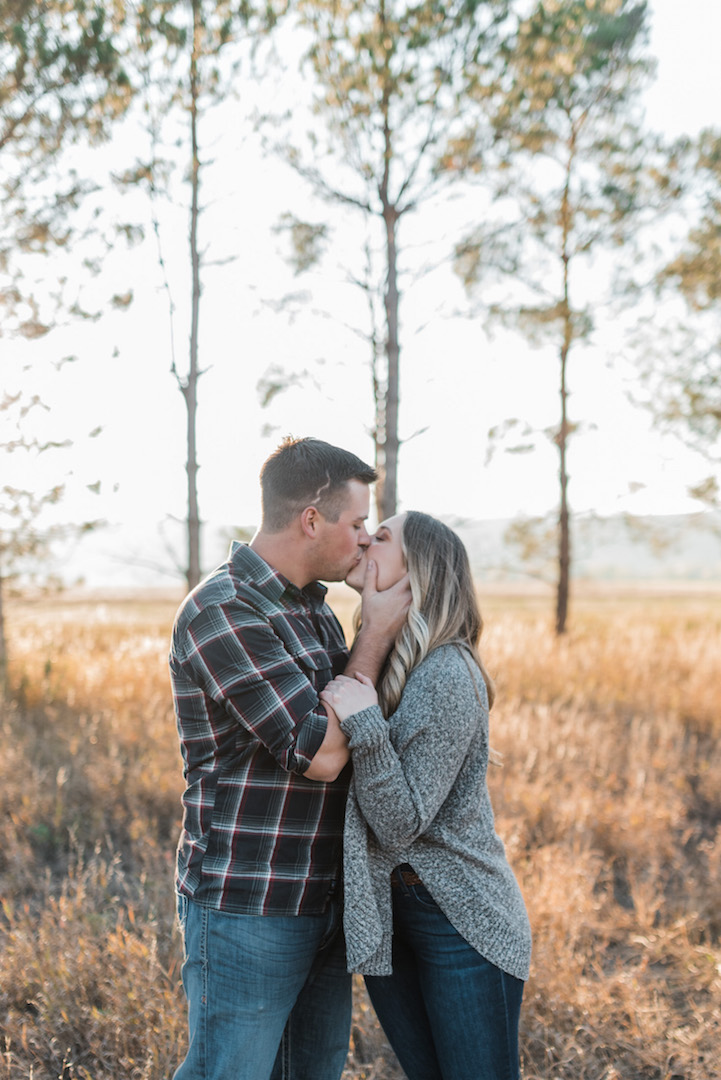Fort Collins couple kissing in field with trees