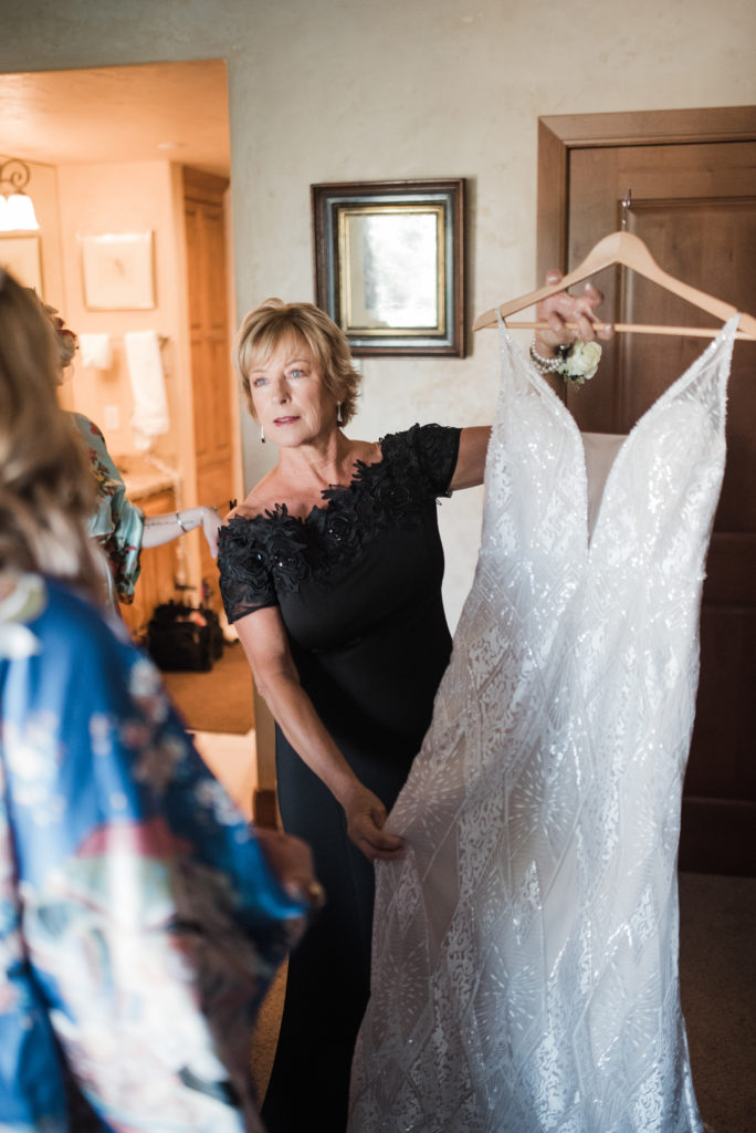 Mom holding bride's dress up