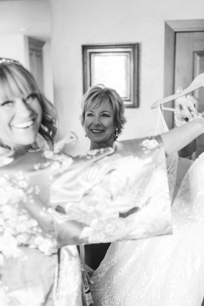 Bride and mom smiling at her dress