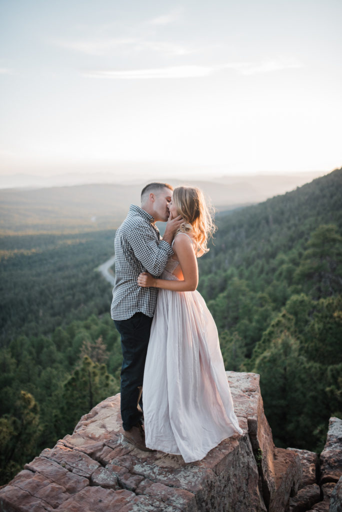 Emily and Andrew kissing on cliff for Arizona engagement