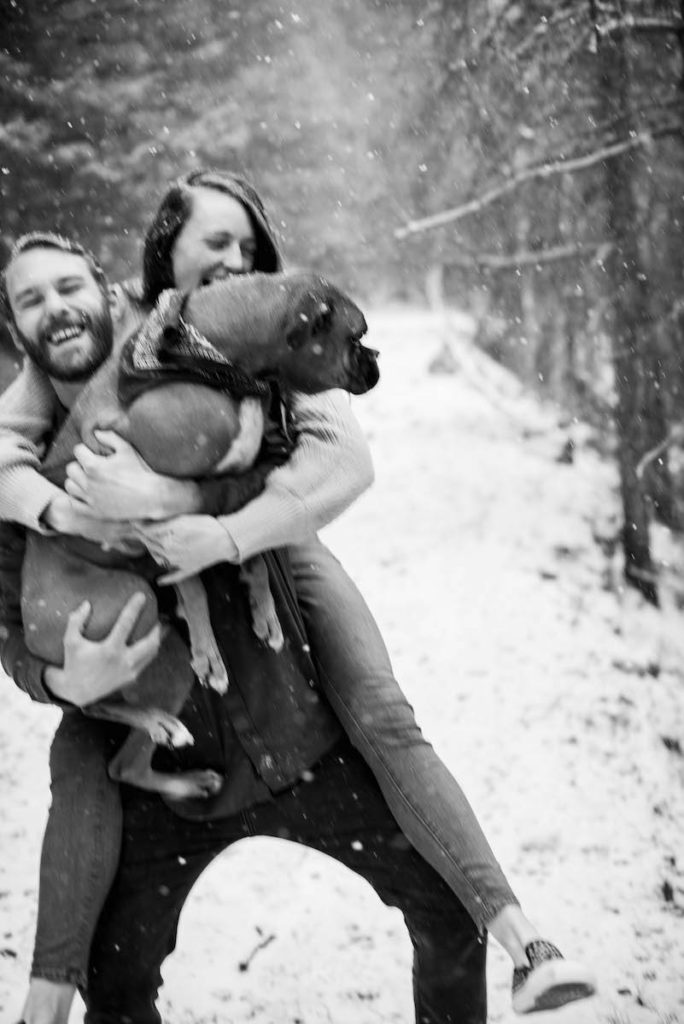 Natalie and Ian holding dog in snow in black and white