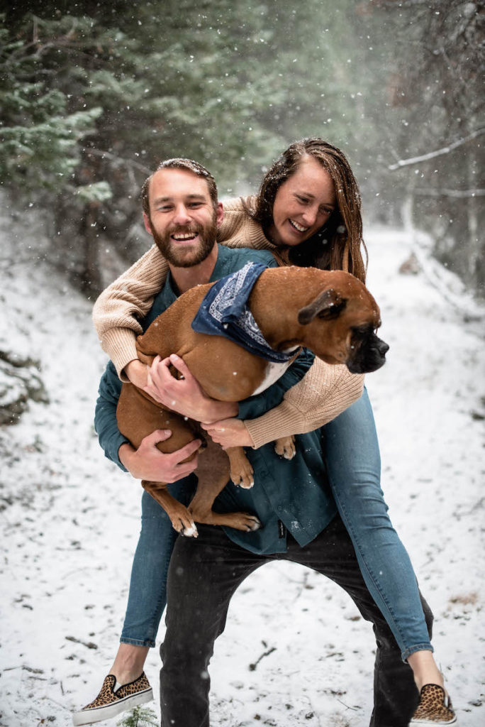 Natalie and Ian holding dog in snow 