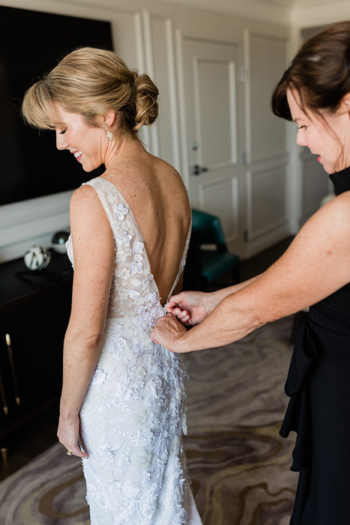 Mom helping bride put dress on for Denver Botanic Garden wedding