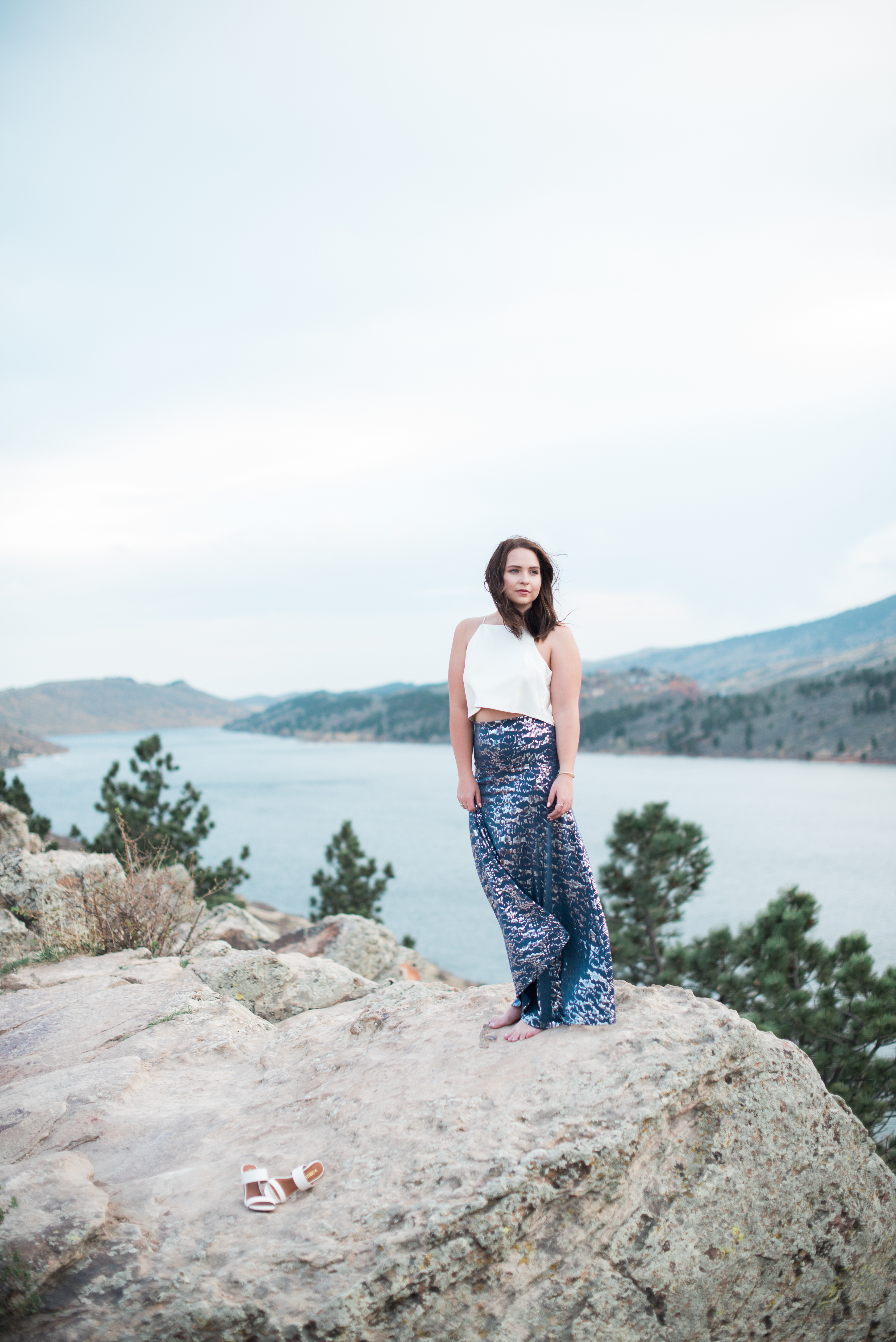 woman standing on cliffs at horsetooth rock portrait session in Fort Collins