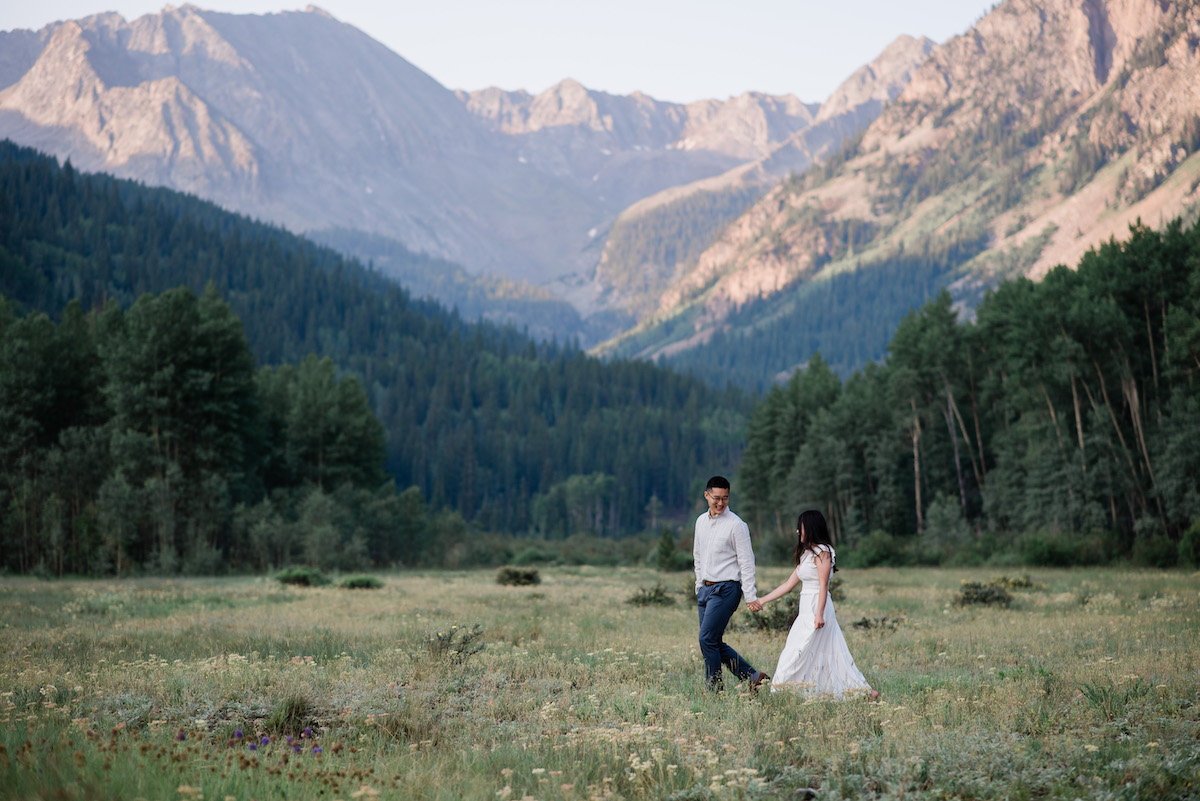 Couple running in field at Aspen engagement